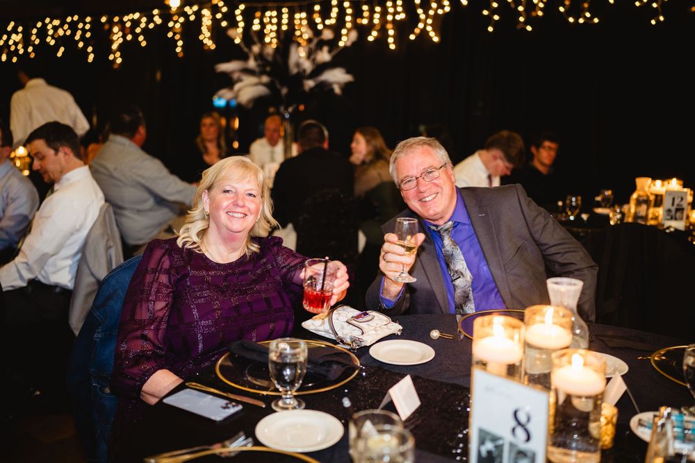 Elegant wedding reception tables decorated with glowing candles and string lights creating a romantic atmosphere.