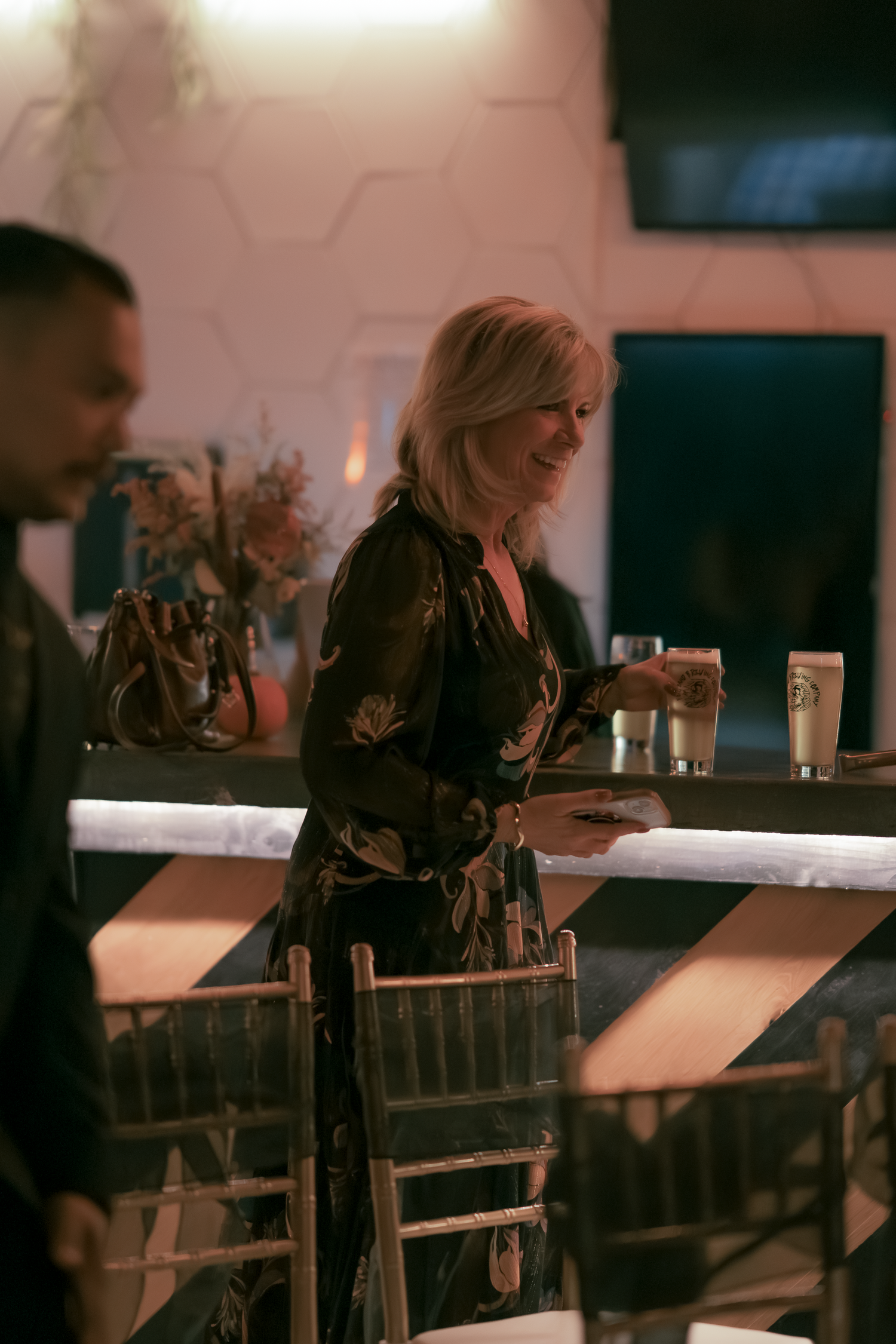 Dimly lit bar scene with patrons seated at counter in evening atmosphere.