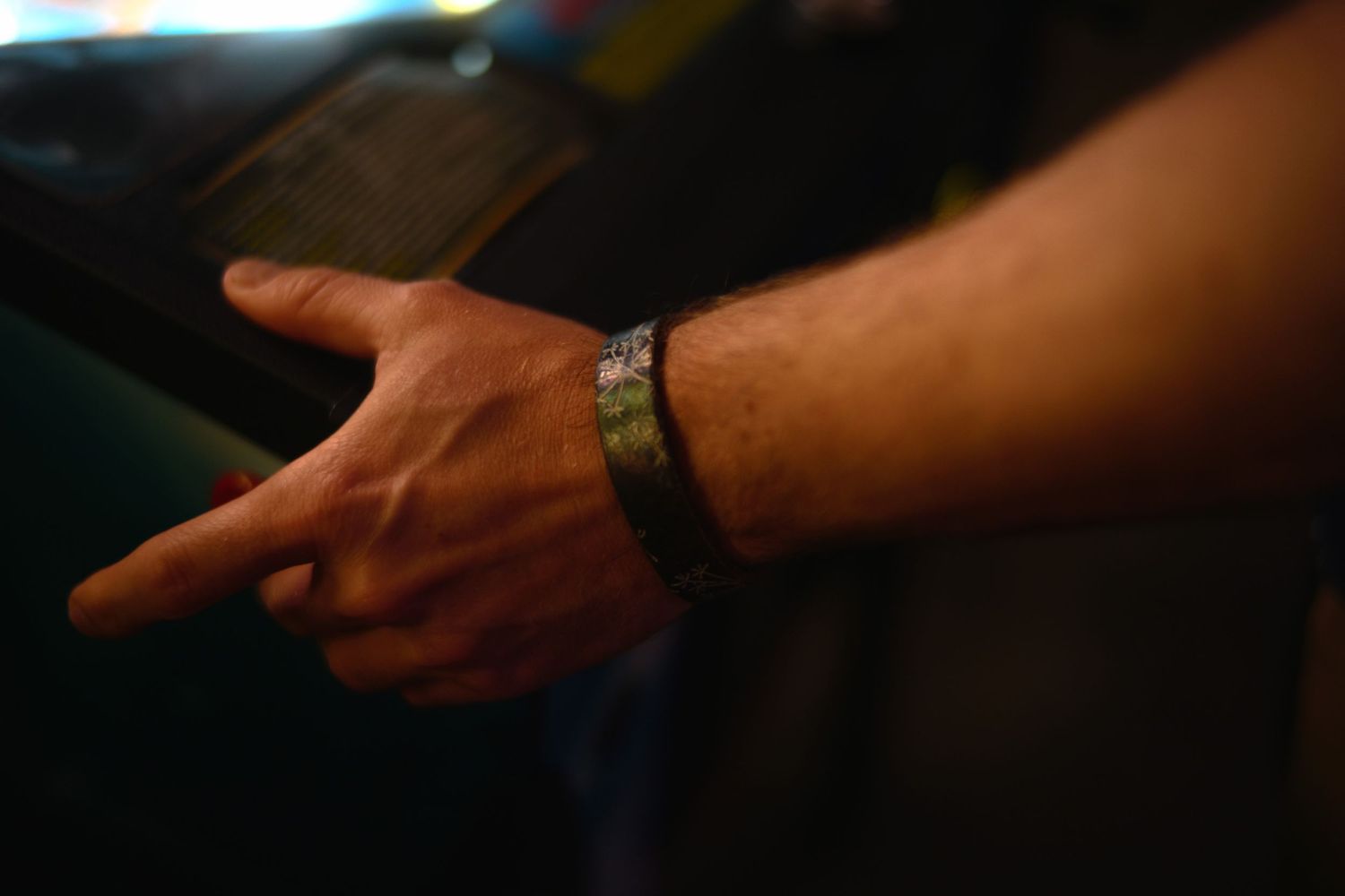 Close-up shot of a hand wearing a watch against a dark background.