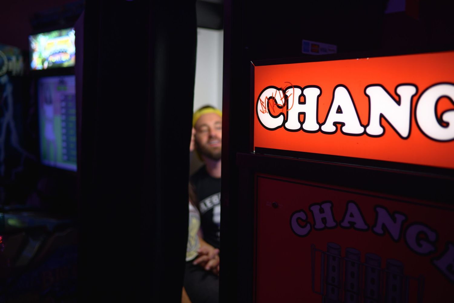 Red illuminated 'CHANG' sign glowing in a dark nightclub or bar setting.