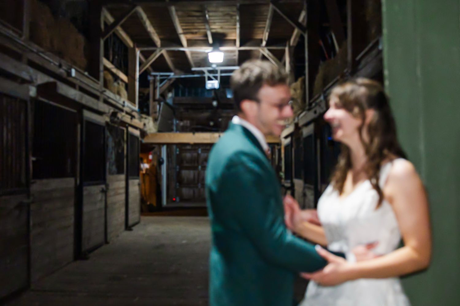 A couple shares a romantic moment in an industrial warehouse setting with dramatic lighting and shadows.
