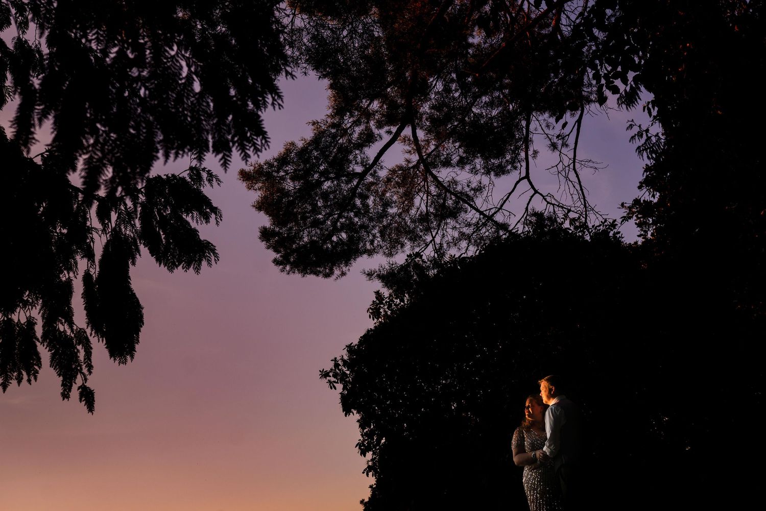 Romantic silhouette of wedding couple at sunset near a glowing lantern, Surrey wedding photography