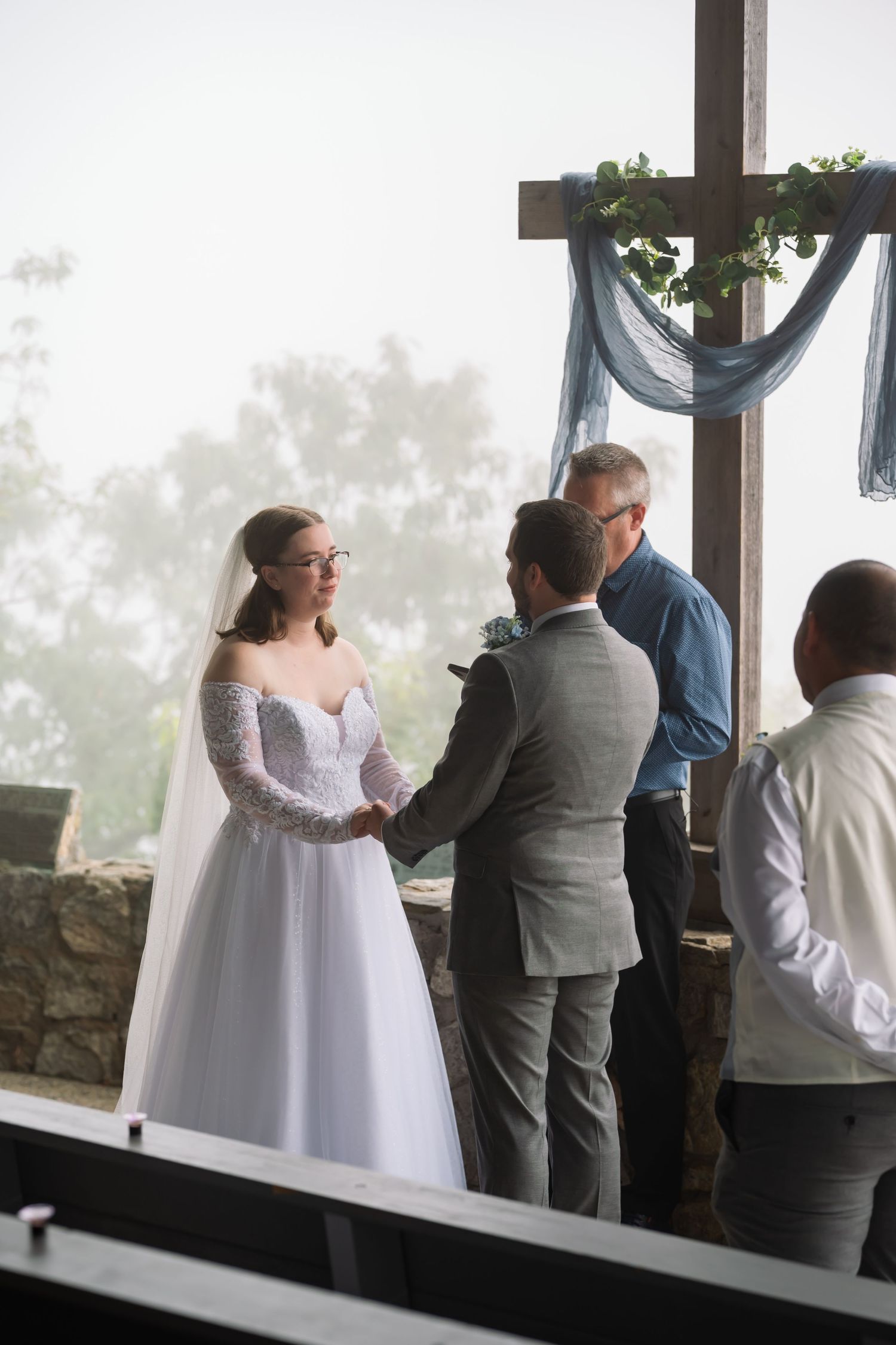 A sequence of four photos showing a bride and groom in a romantic first look moment by large windows.