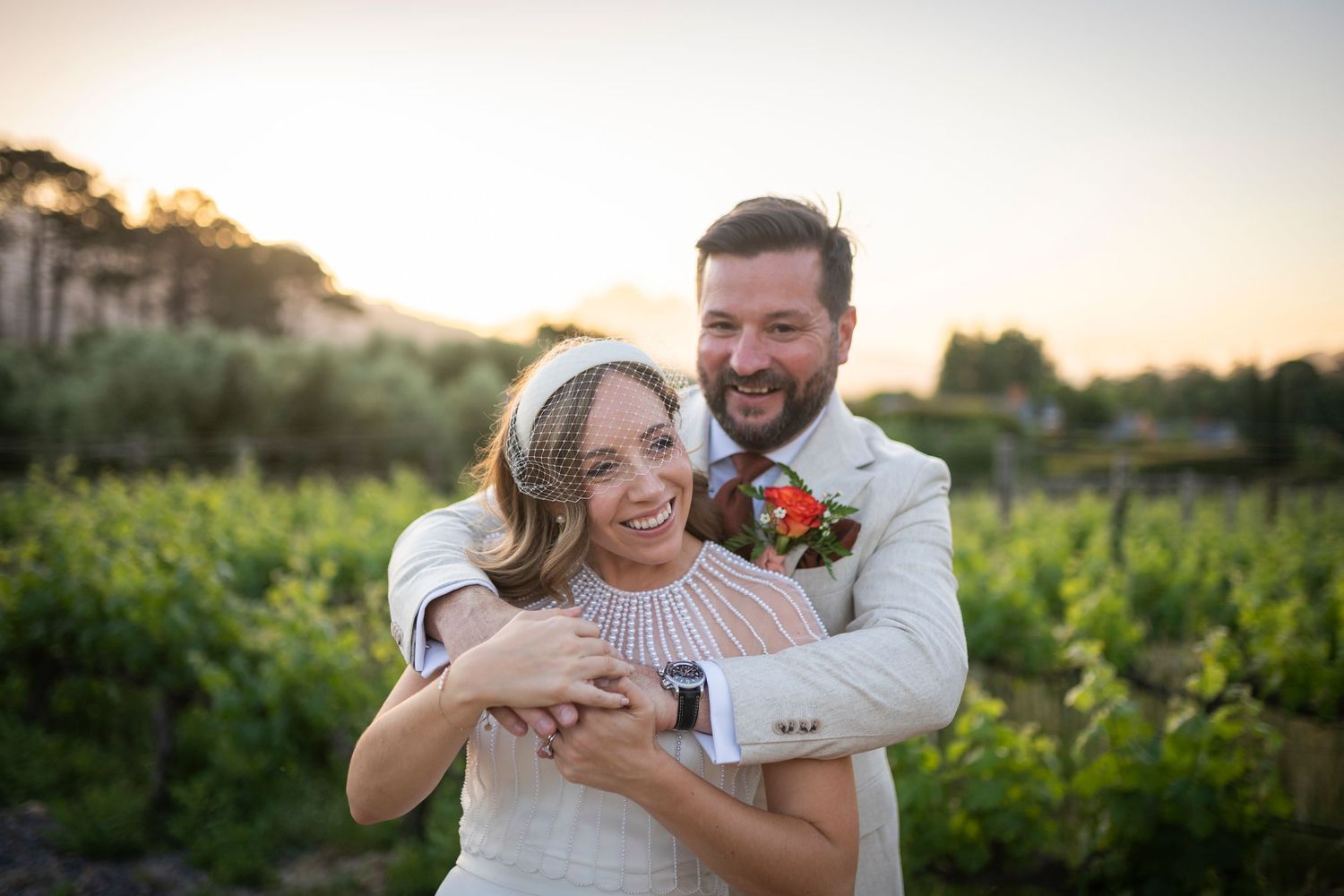 Couple shares joyful moments during golden hour engagement photoshoot in lush outdoor setting.