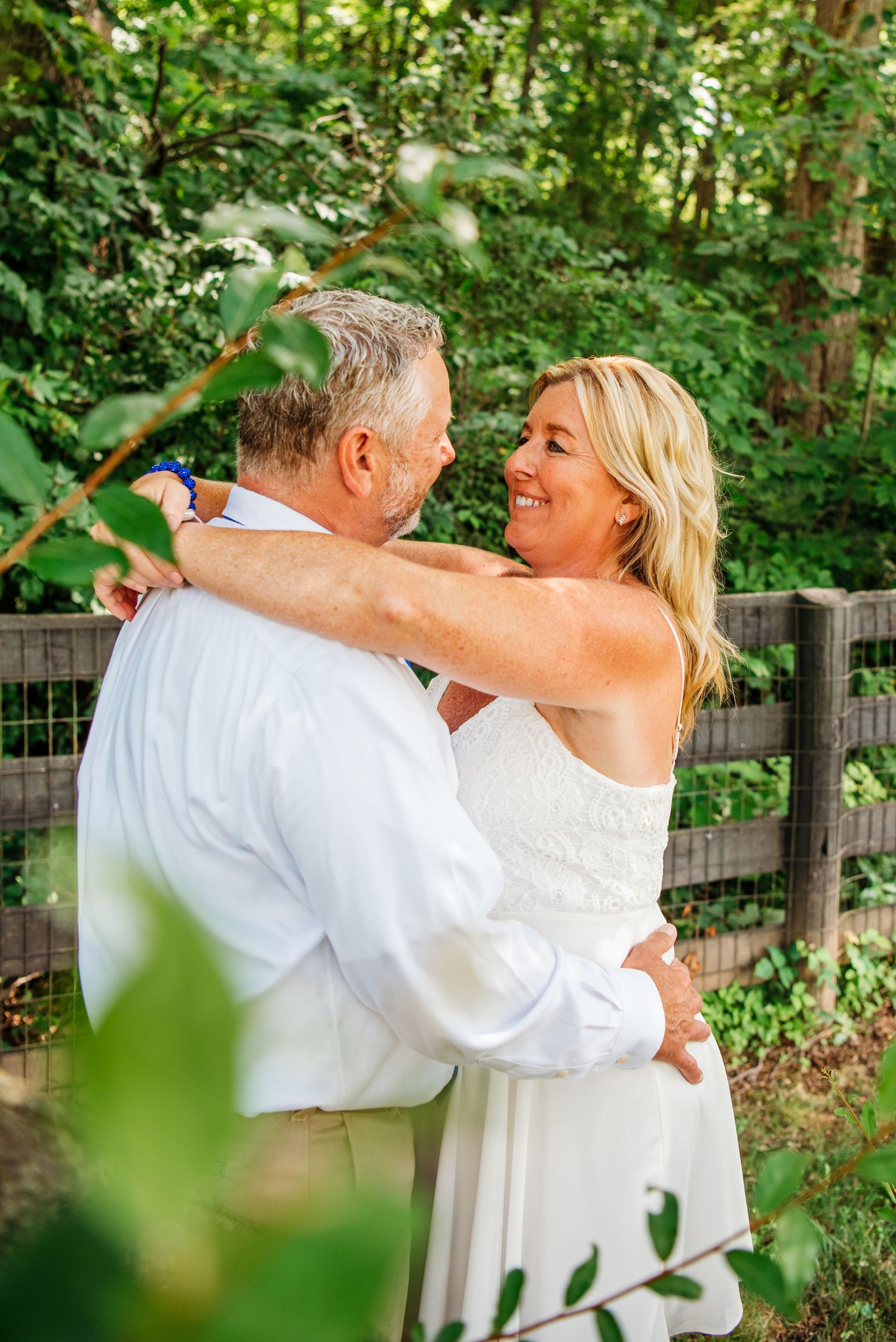 A romantic moment captured in a lush garden setting with greenery and natural light.