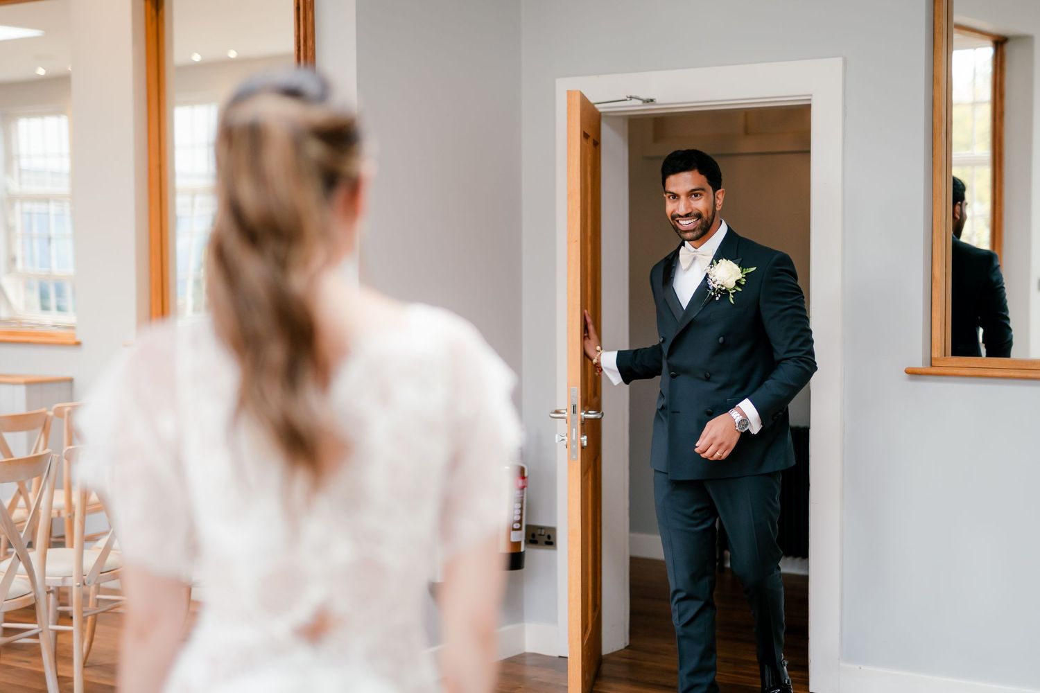 First look in British wedding outfits — bride in Pronovias gown, groom in tuxedo, fusion wedding photography