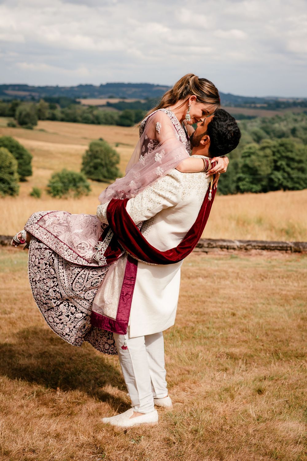 Jess and Pram’s British-Indian fusion wedding at Bredenbury Court Barns — bride in burgundy lengha, groom in white sherwani