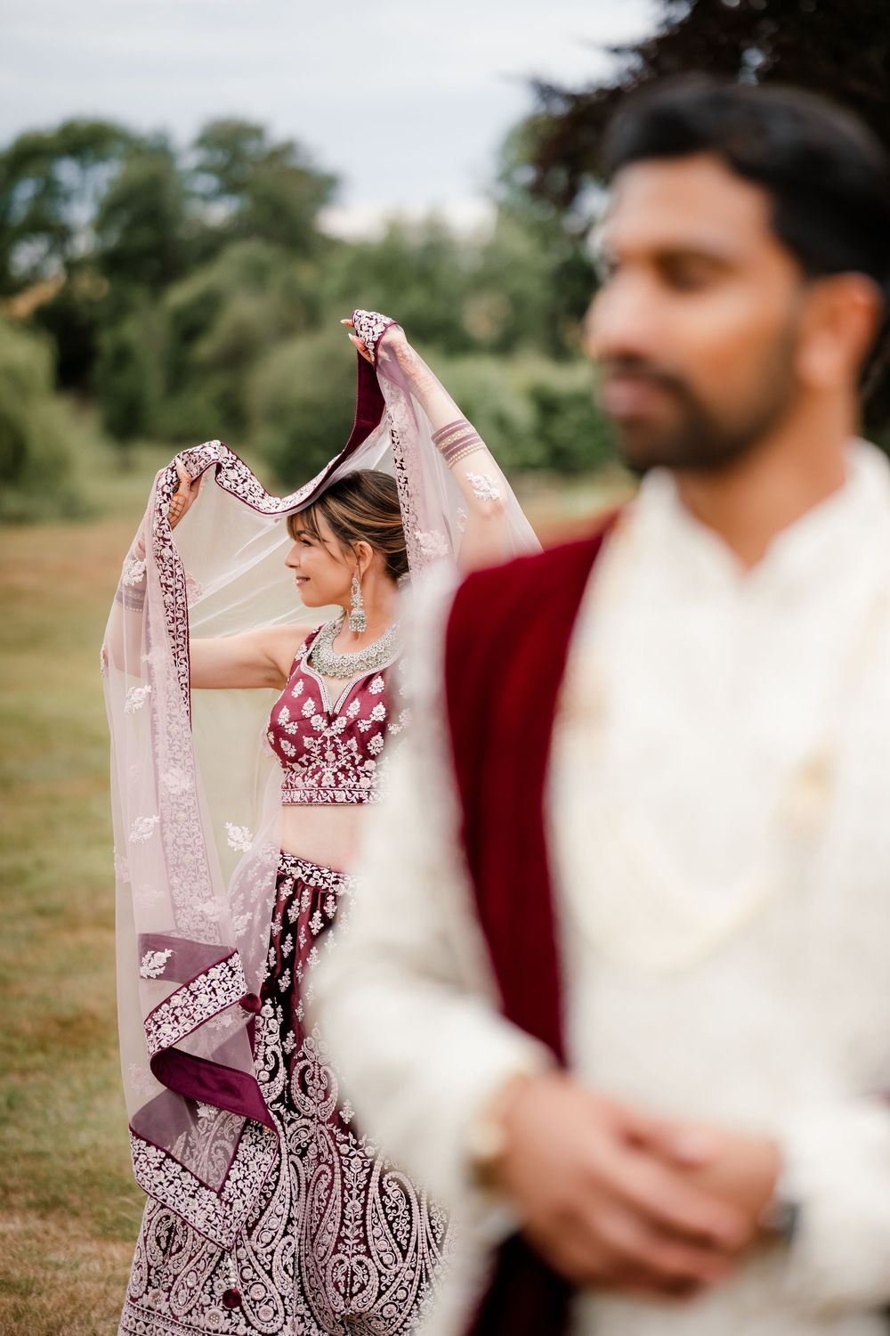 Jess and Pram’s British-Indian fusion wedding at Bredenbury Court Barns — bride in burgundy lengha, groom in white sherwani