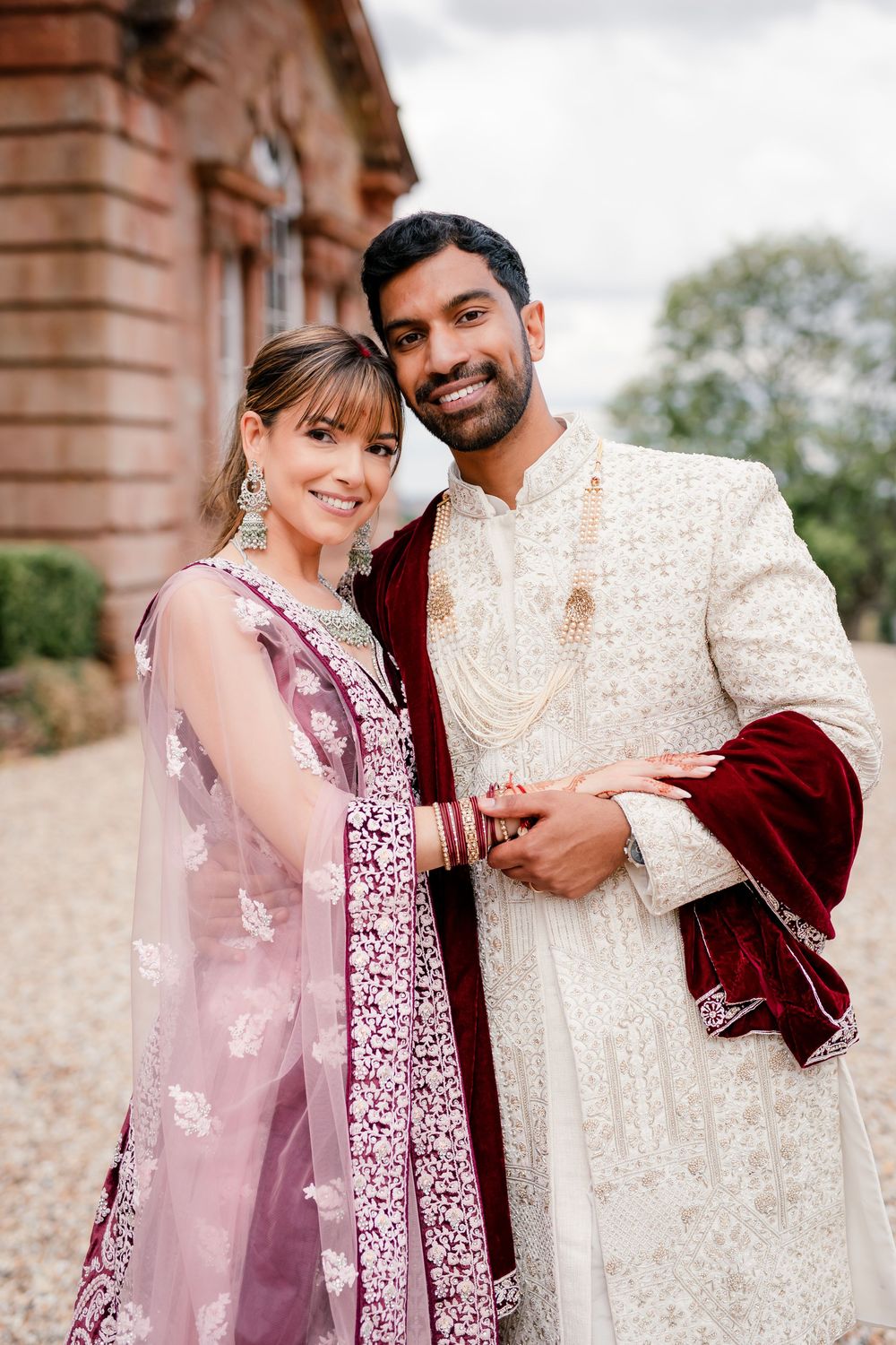 Jess and Pram’s British-Indian fusion wedding at Bredenbury Court Barns — bride in burgundy lengha, groom in white sherwani