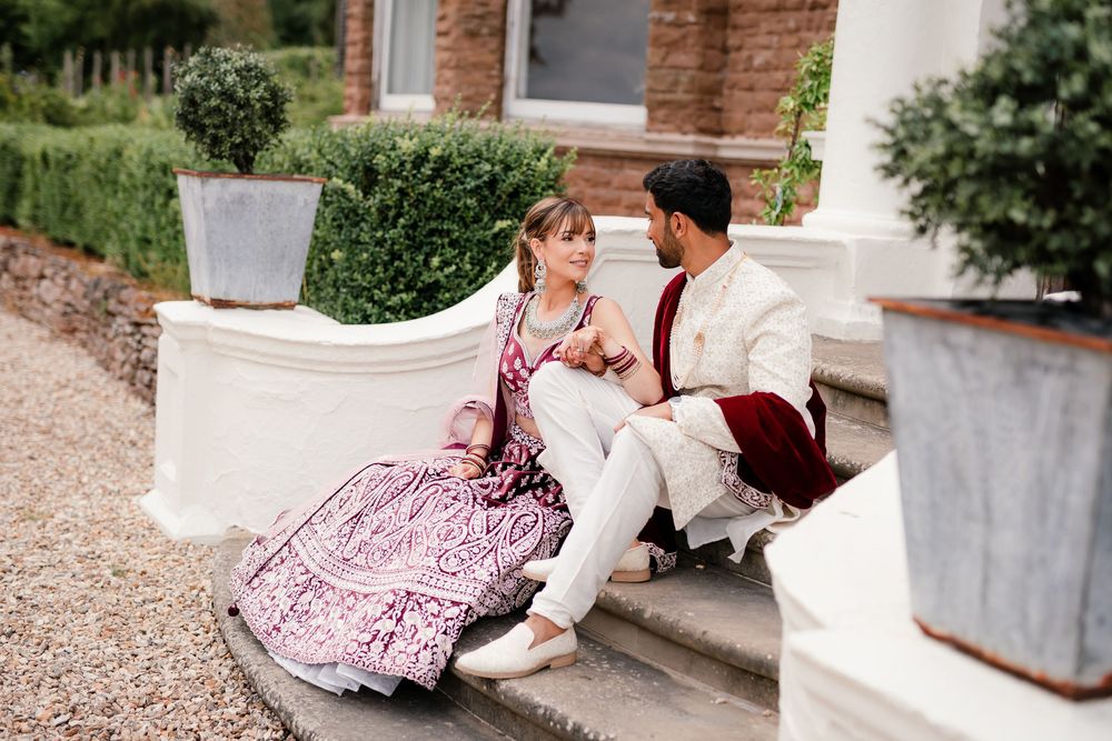 Jess and Pram’s British-Indian fusion wedding at Bredenbury Court Barns — bride in burgundy lengha, groom in white sherwani