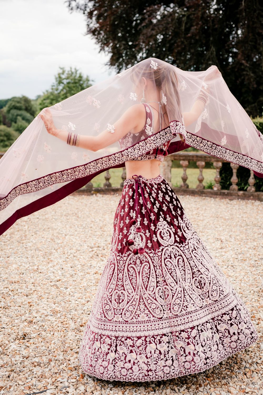 Jess and Pram’s British-Indian fusion wedding at Bredenbury Court Barns — bride in burgundy lengha, groom in white sherwani