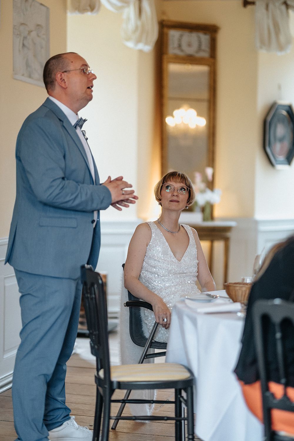 A sequence of candid moments showing two people interacting in an elegant indoor setting with white walls and decor.