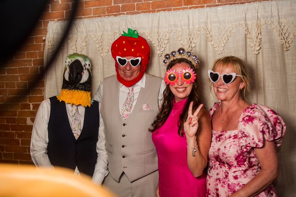 Wedding photo booth session with guests wearing fun props and colorful outfits.