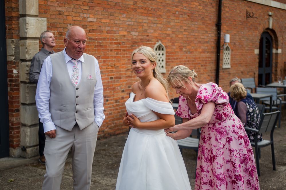 Wedding celebration outside brick venue with guests in formal attire.
