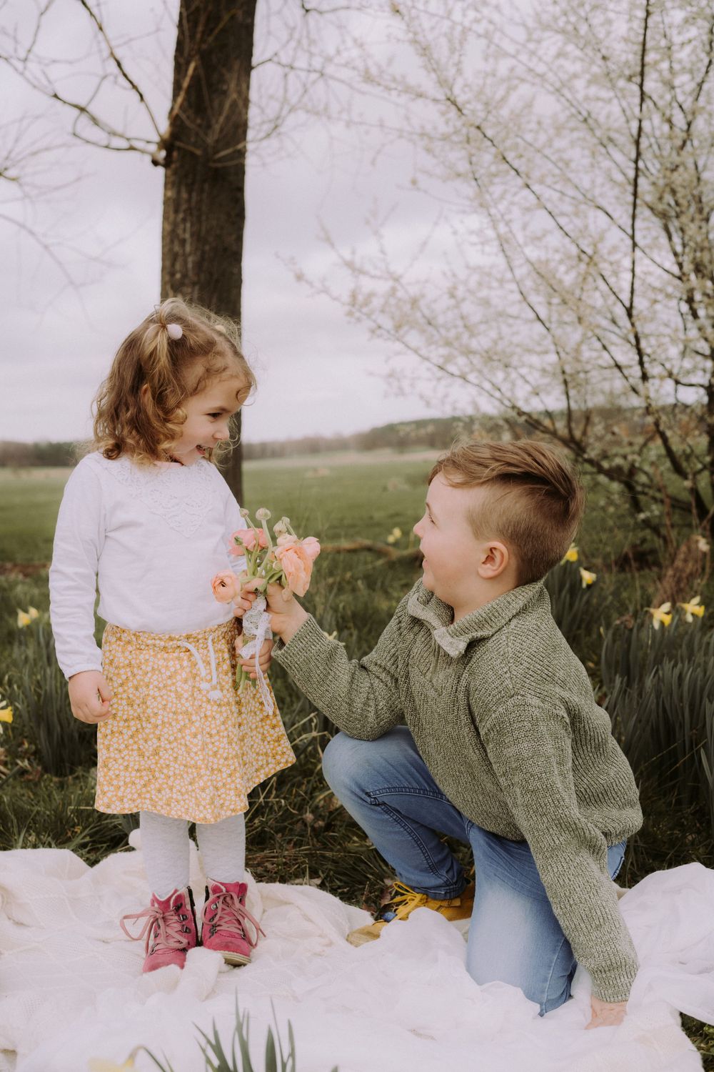 A sweet springtime scene with blooming flowers and a grey sweater against yellow daffodils.