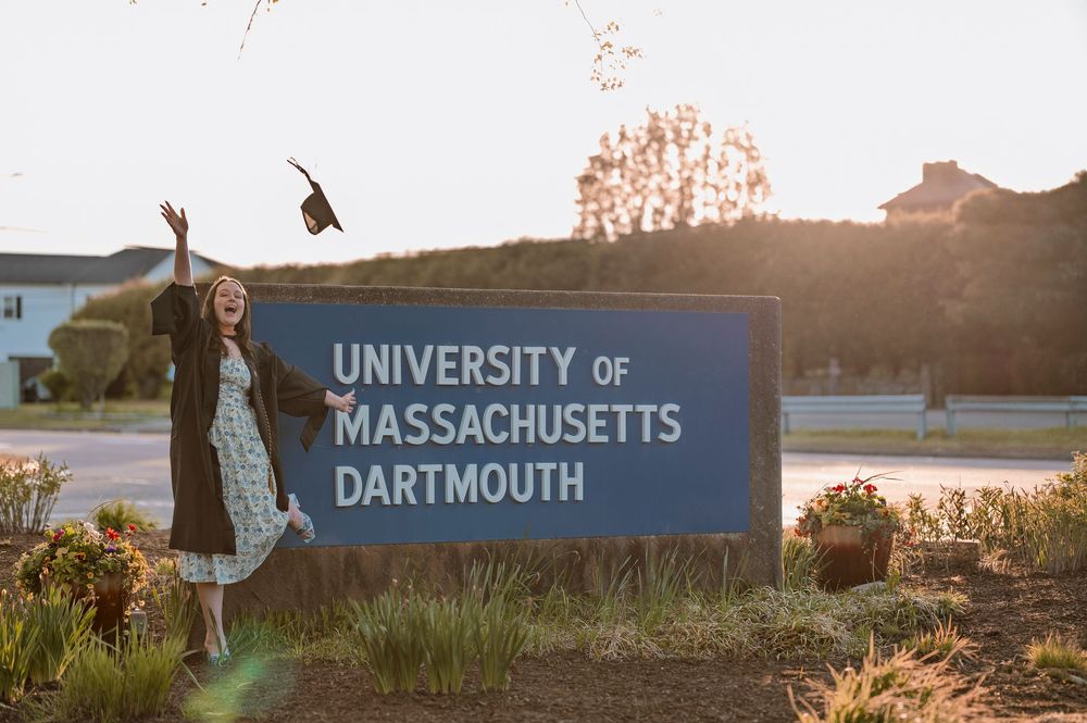 Campus signage for the University of Massachusetts Dartmouth entrance with sunset lighting across multiple panels.