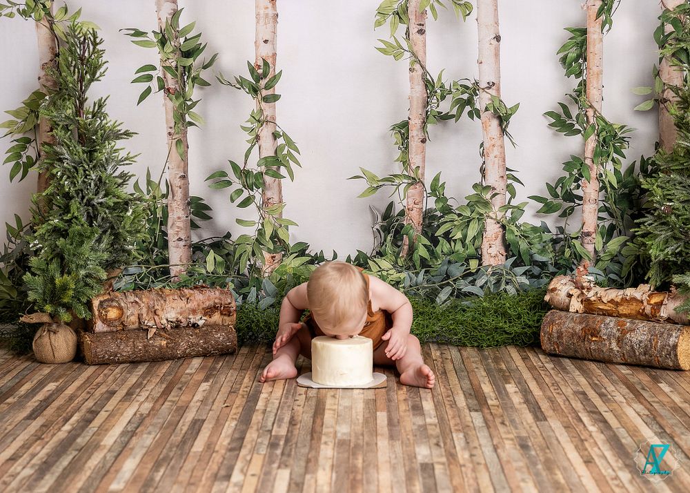 Child plays with white cube prop against woodland backdrop with birch trees.