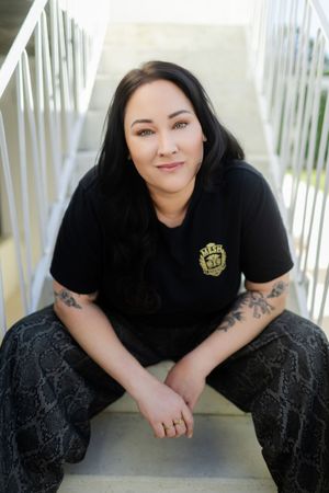 A person in black attire poses on white stairs in a series of connected portrait shots.