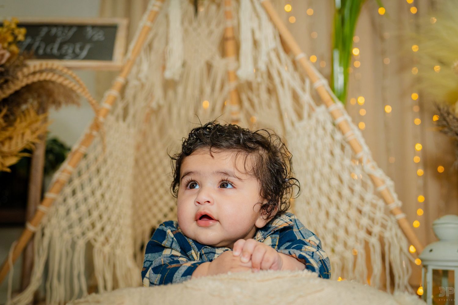 Young child smiling brightly during a portrait session, captured in soft lighting with a simple background