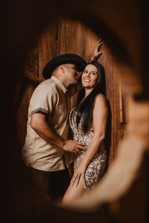 Intimate moment captured through circular frame against rustic wooden backdrop.