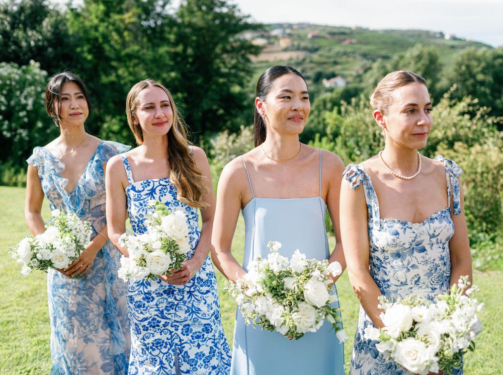 Bridesmaids in blue floral dresses with white bouquets at Six Senses Douro Valley.