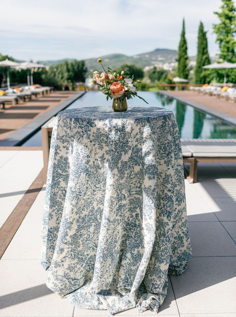 Stylish high table with floral centerpiece overlooking the pool and scenic vineyards.