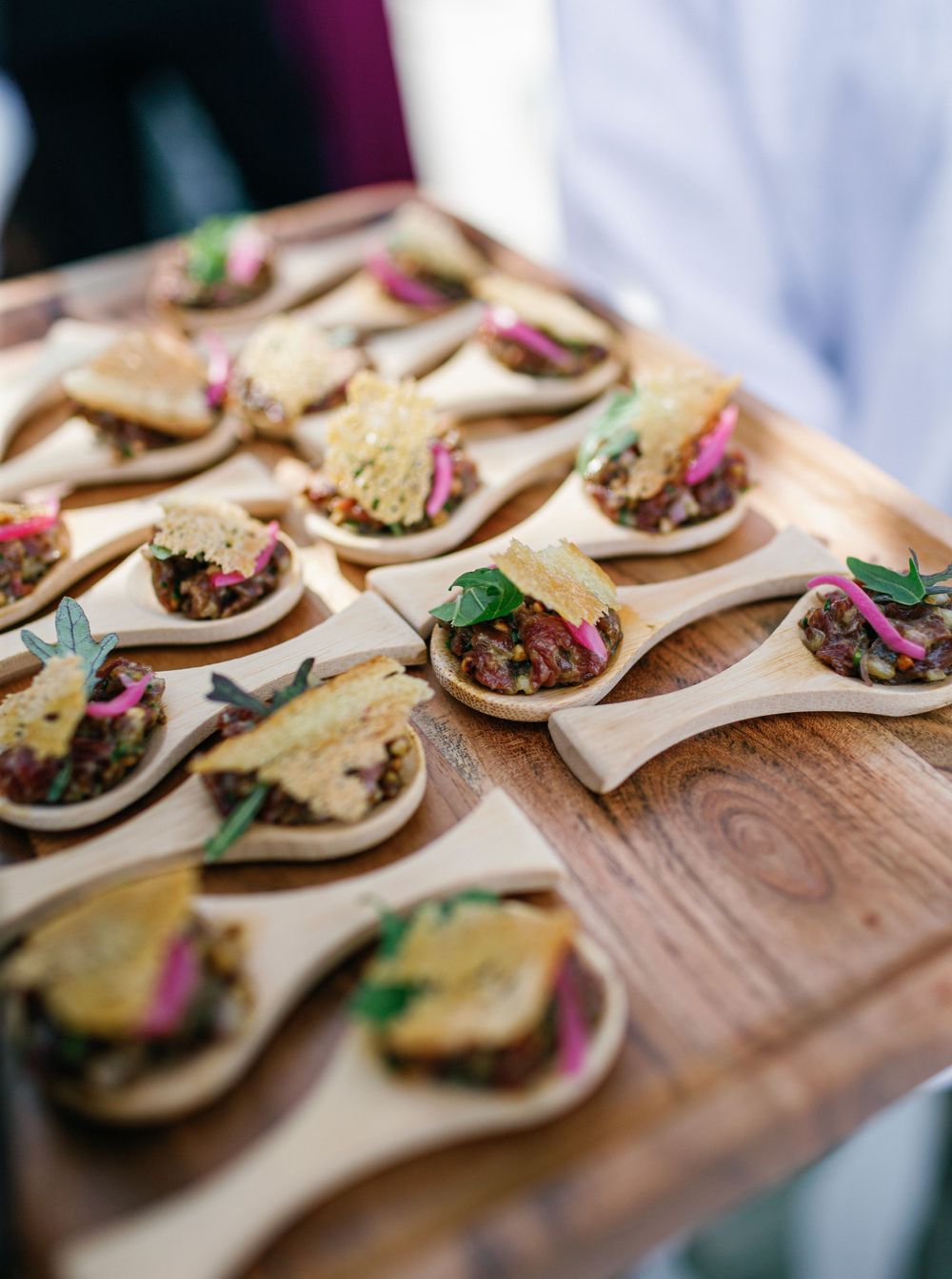 Plated gourmet hors d'oeuvres on wooden spoons, ready to be enjoyed by guests.