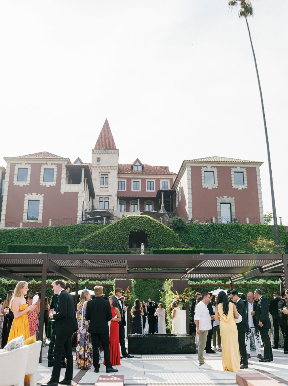 Guests socializing outdoors with the stunning facade of the villa and surrounding vineyards.