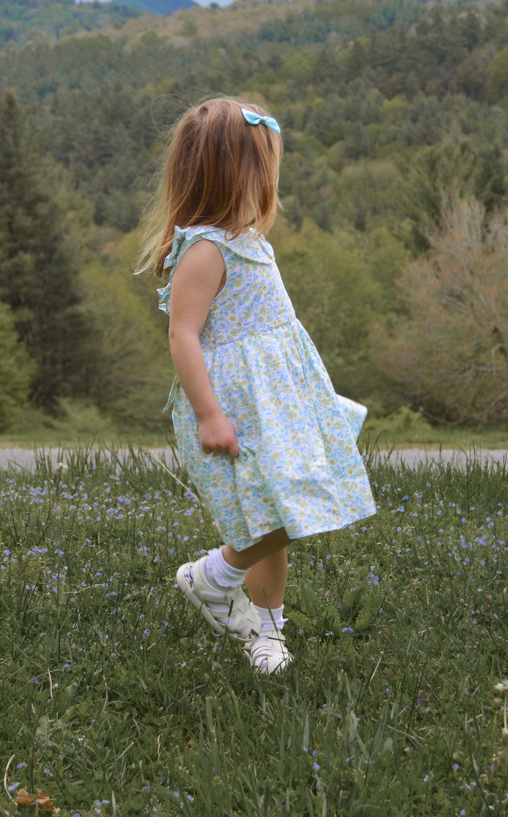 child twirling in a grass field for family photo session