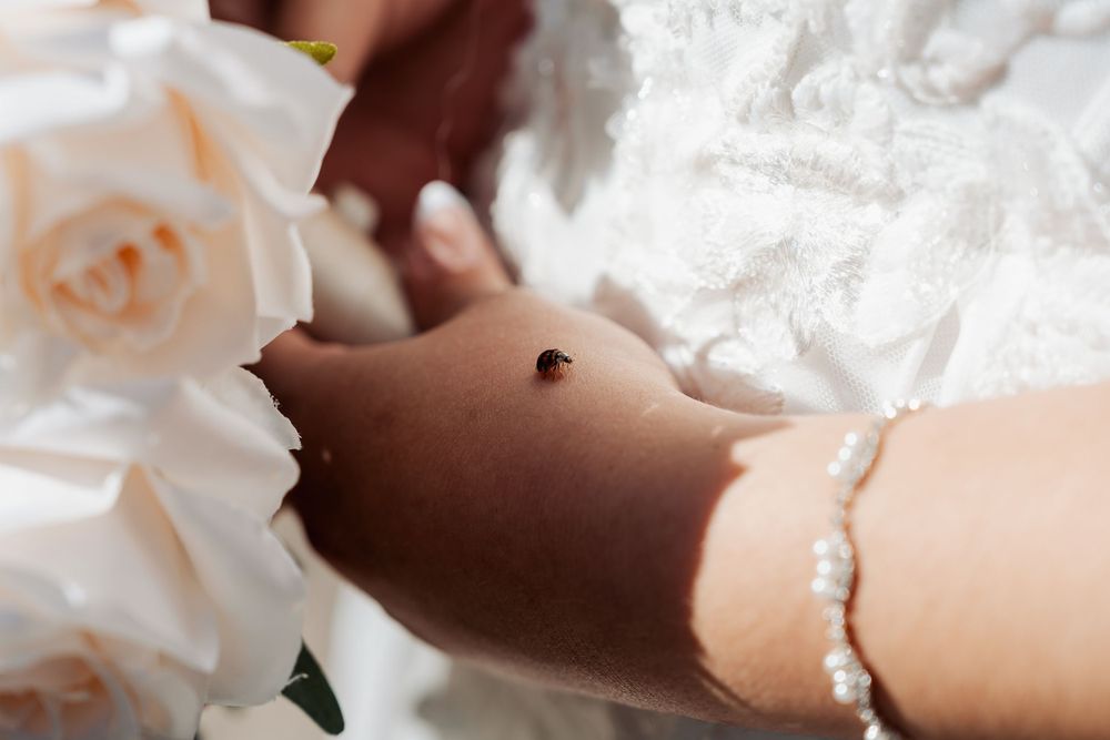 Delicate pearl bracelet and wedding dress details in soft lighting.