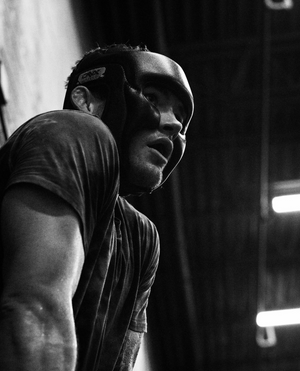Black and white portrait of an athlete in training with focused determination captured in dramatic lighting.