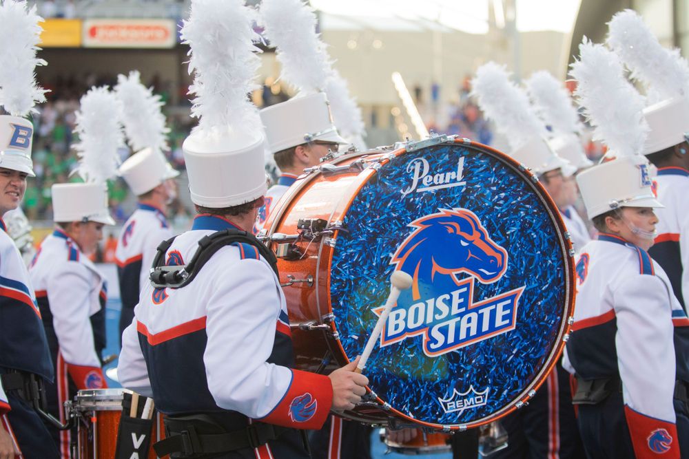 A marching band drum with the Boise State logo displayed prominently during a performance with the band in the background.