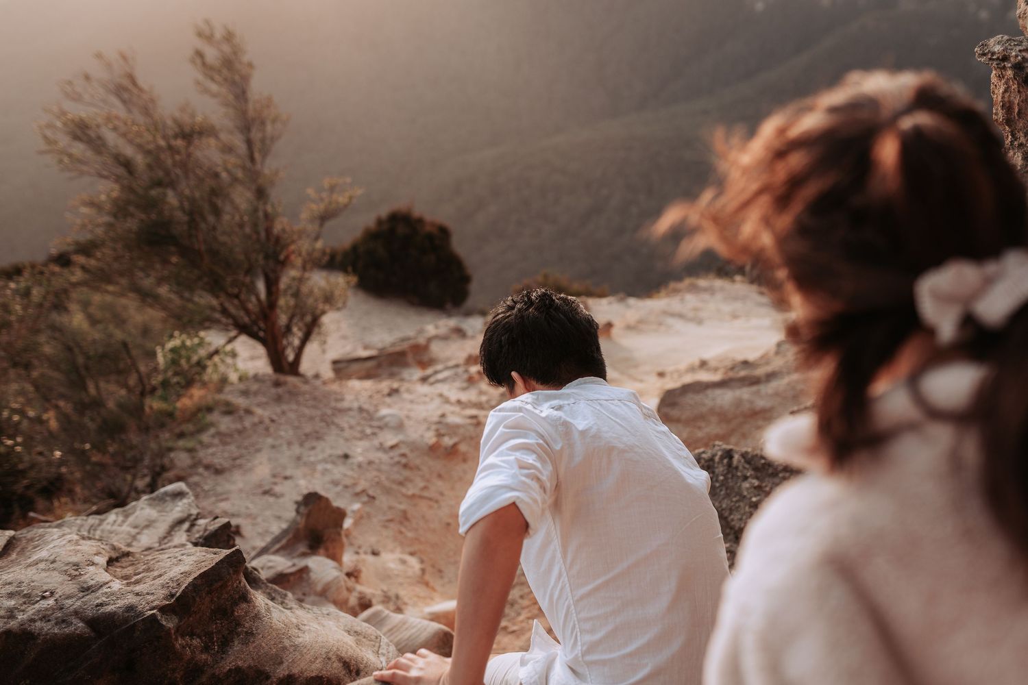 Two people enjoying a scenic mountain view together at sunset.