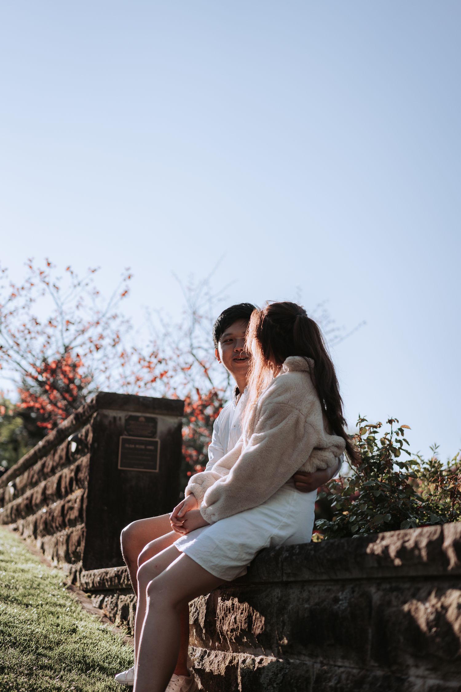 A romantic scene on stone steps surrounded by spring blossoms and greenery.