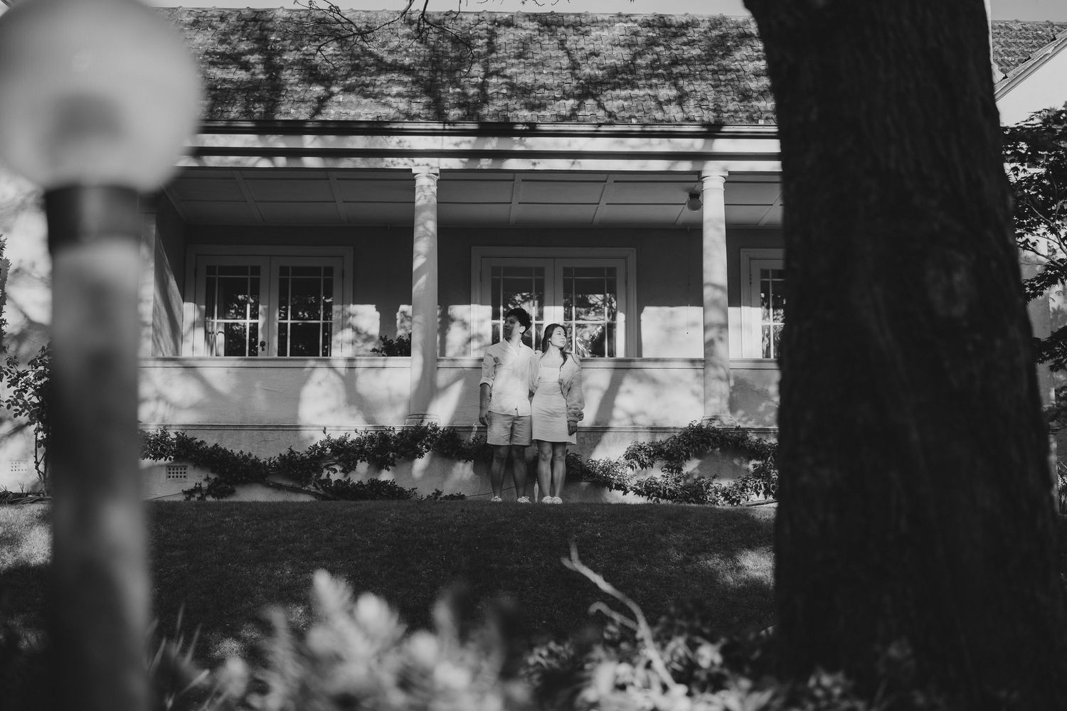 A vintage black and white photograph showing people gathered on a historic porch.