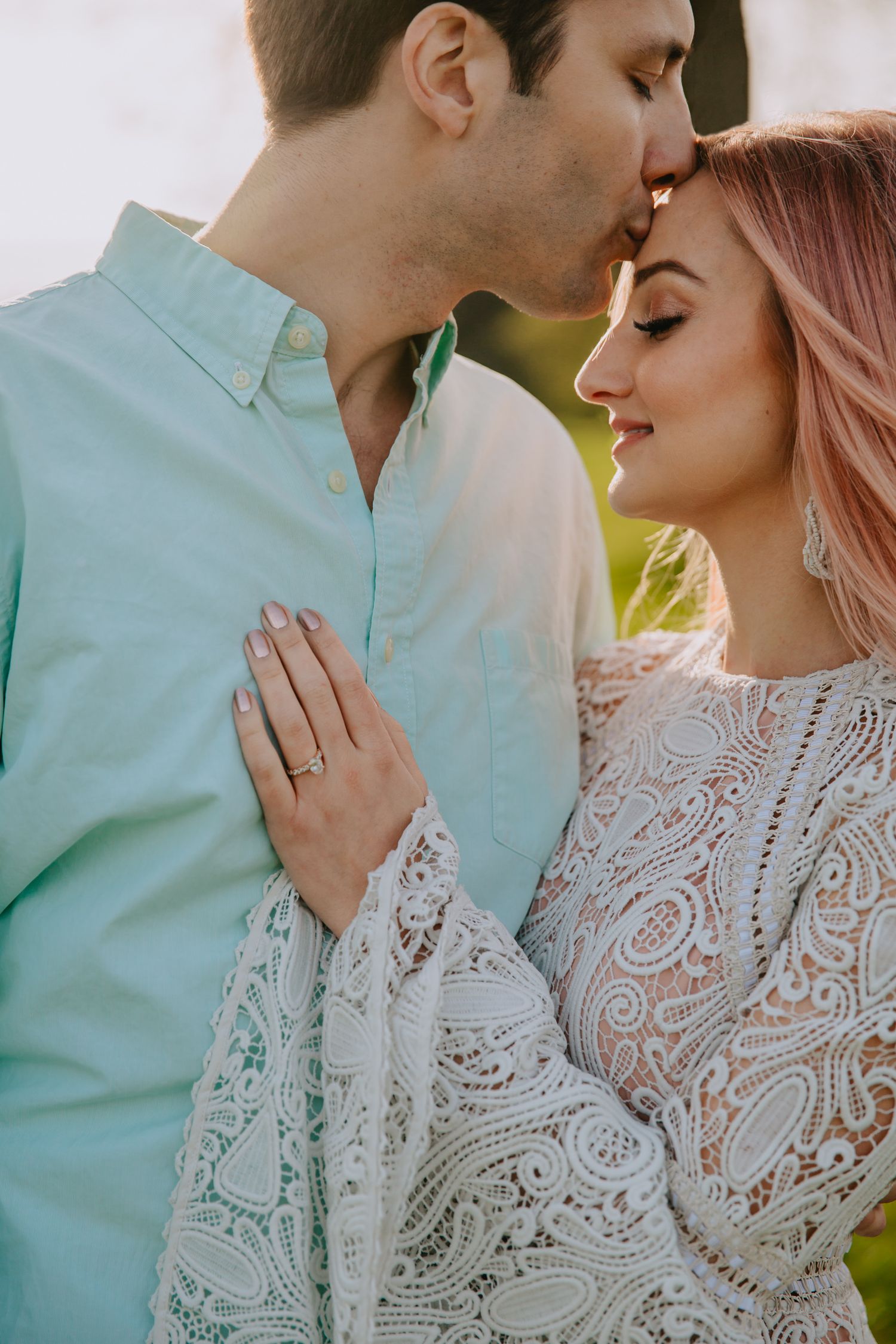 A tender romantic moment between a couple wearing mint green and white lace, captured in soft natural lighting.
