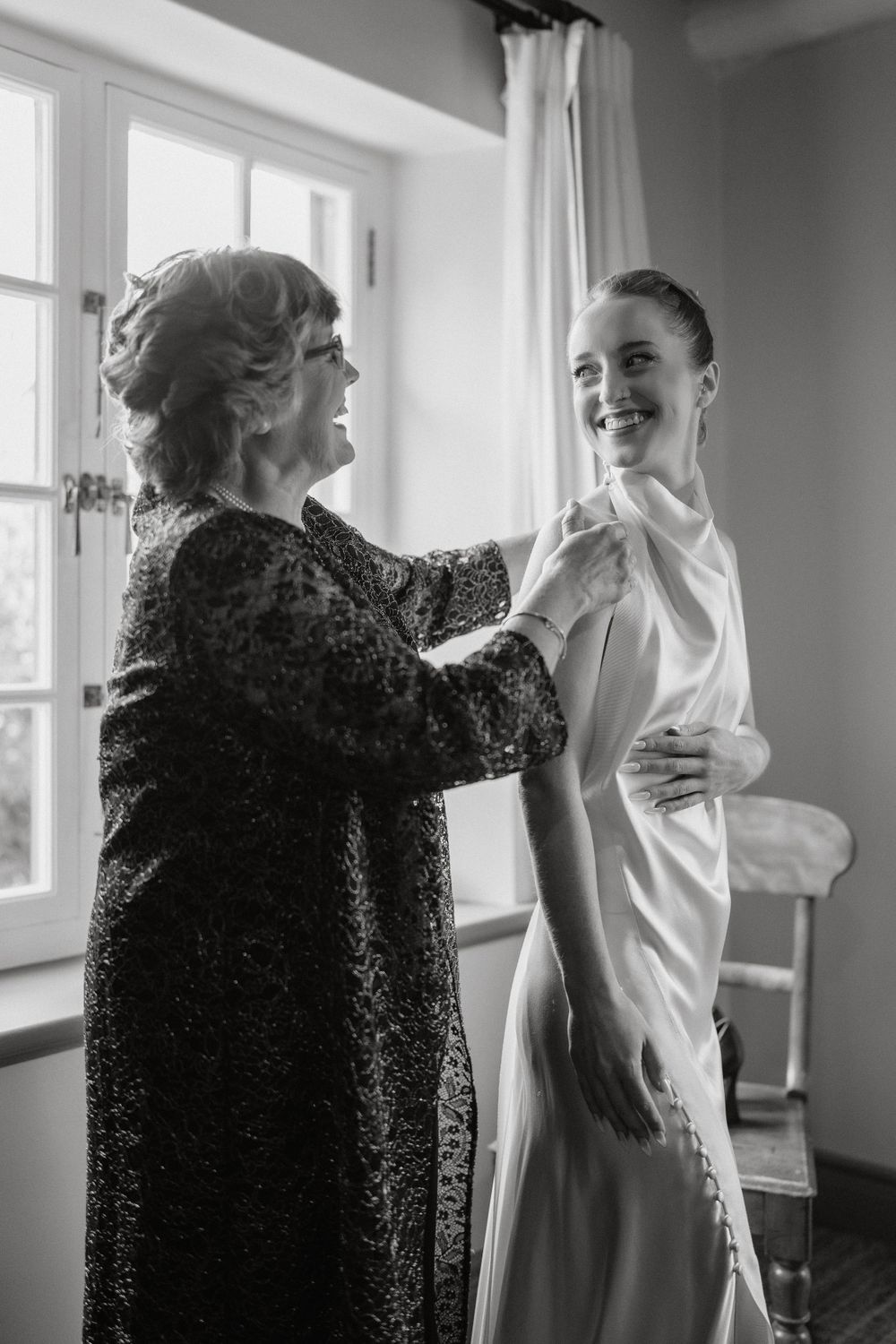 A heartwarming black and white moment between two people as they share a joyful interaction in a sunlit room.