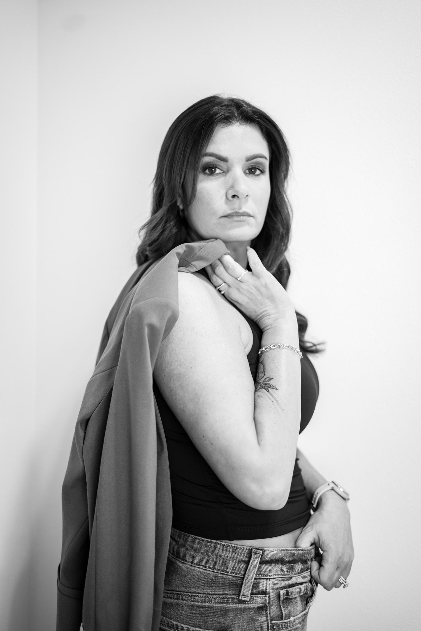 Professional fashion portrait series featuring black tank top and denim against white background.