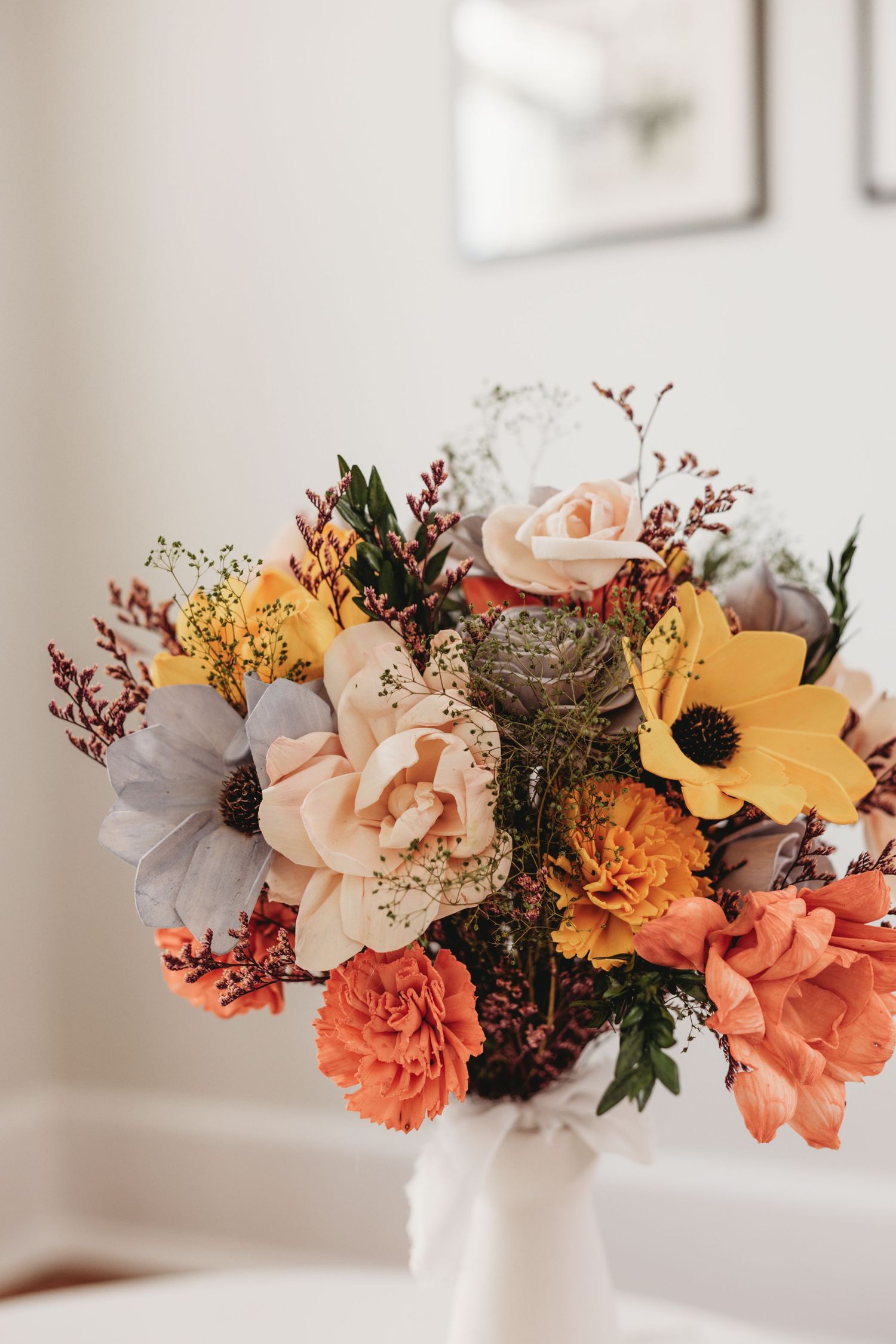 Beautiful floral arrangement with coral, peach and yellow blooms in a white vase.