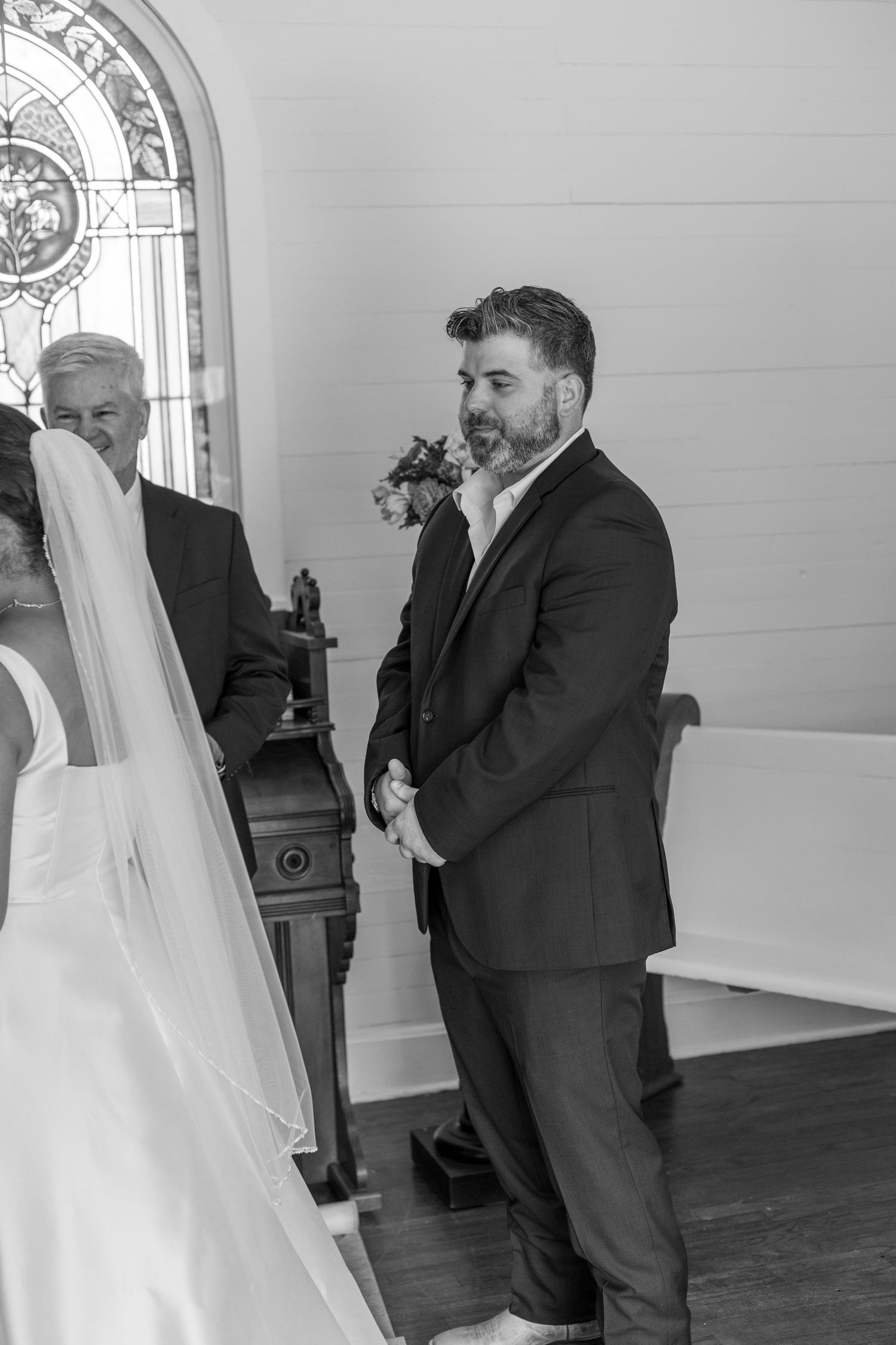 Emotional black and white wedding sequence inside an elegant room with arched windows.