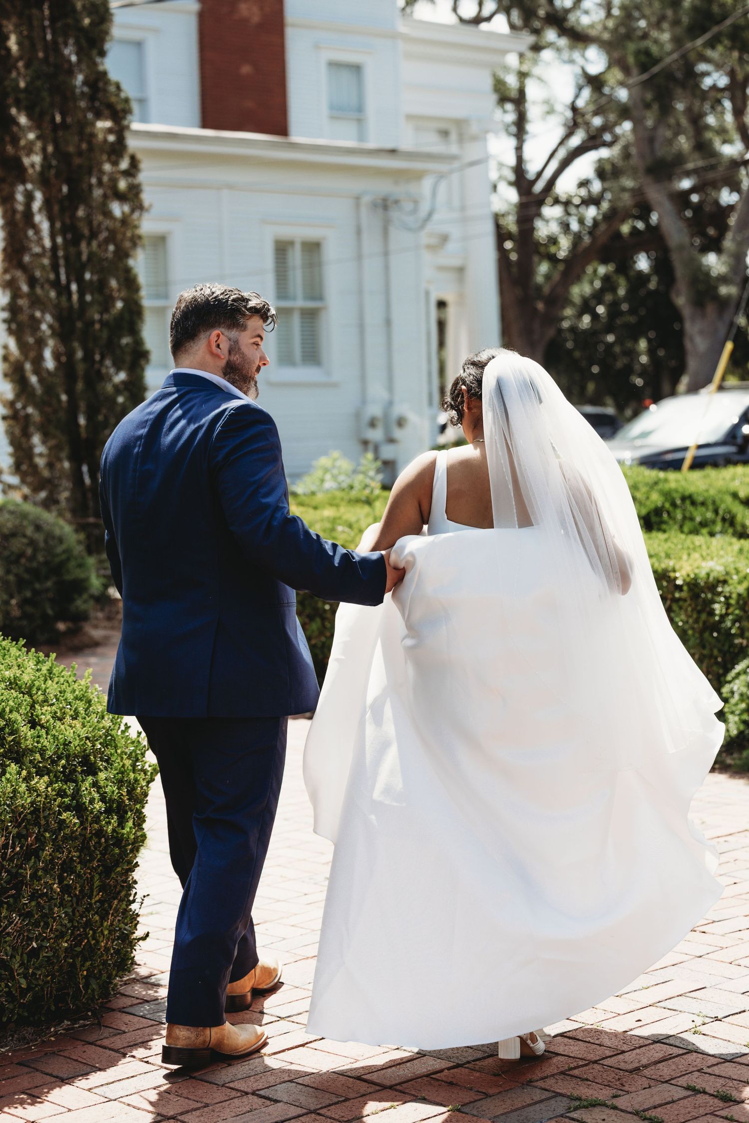 Series showing couple walking on brick pathway with flowing white wedding dress.