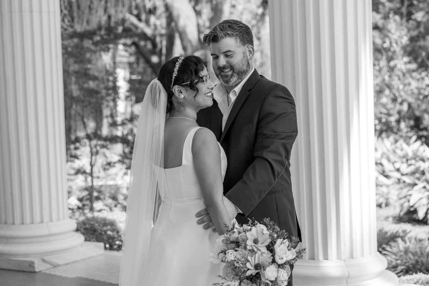 Black and white wedding portraits captured on a classic columned porch.
