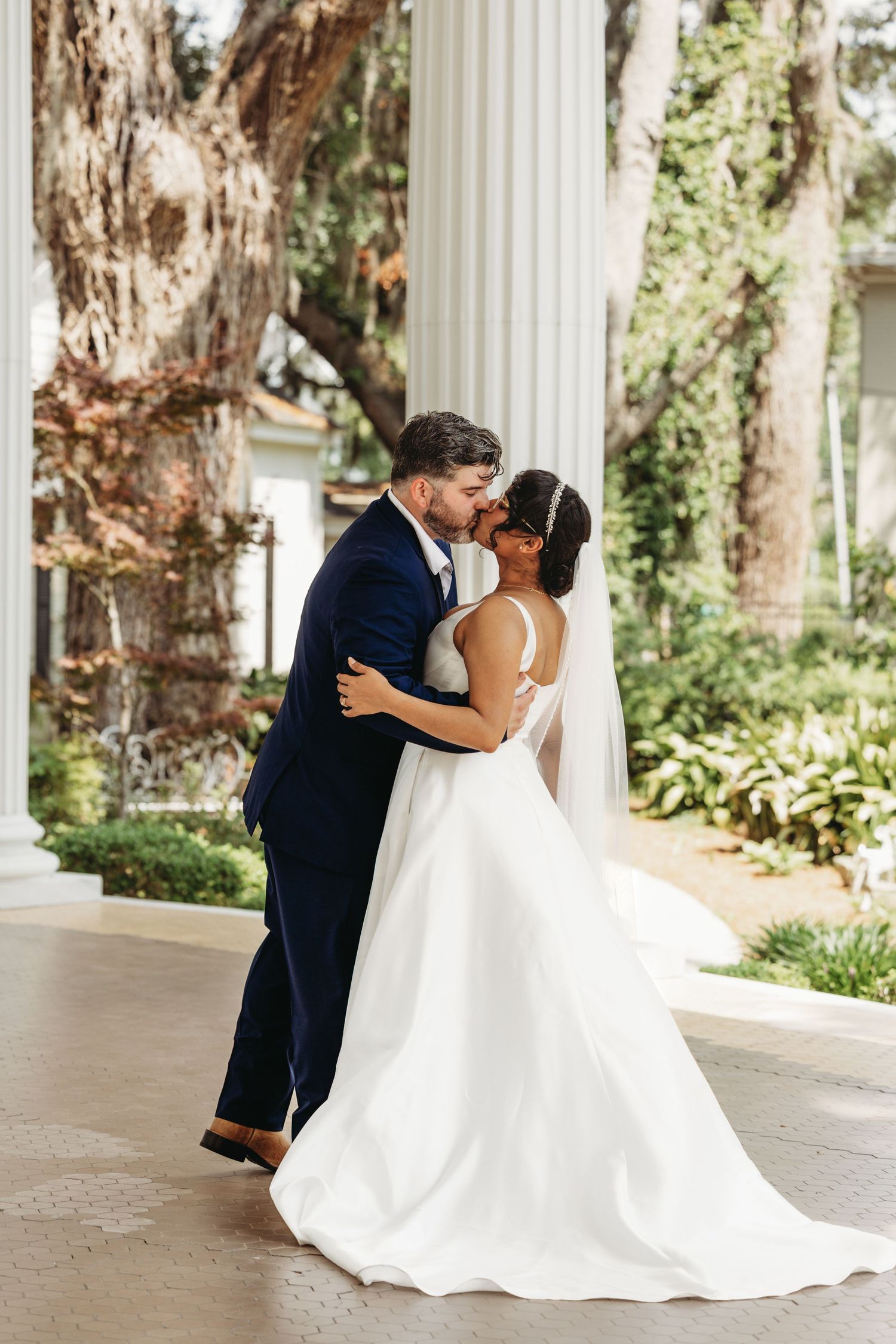 Romantic wedding portraits captured under a covered colonnade with natural lighting.
