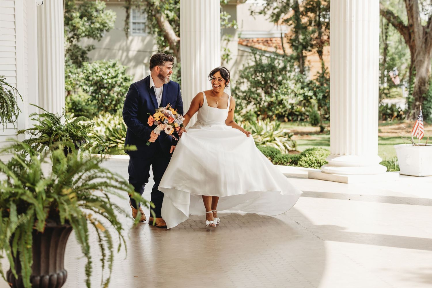 Wedding photos taken under elegant white columns with palm trees in background.