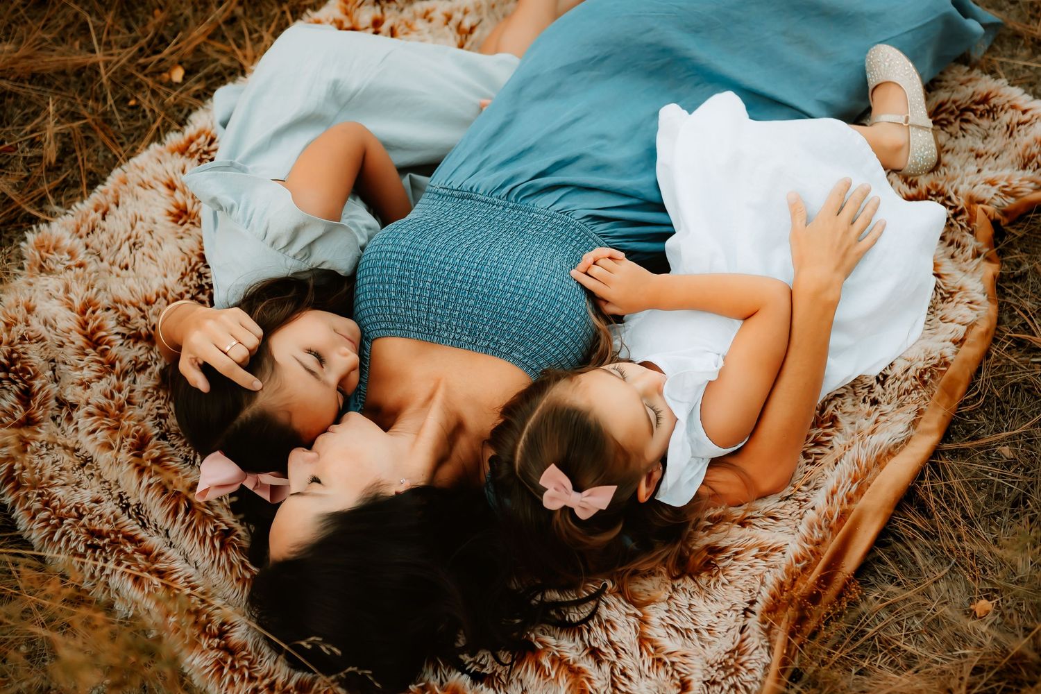 Mother snuggling with daughters during family session in Tucson, Arizona