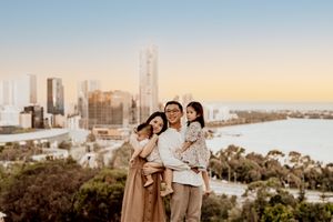 Family enjoying sunset view of Brisbane city skyline from Mount Coot-tha lookout in Australia.
