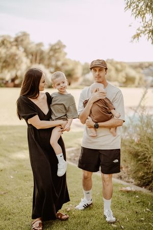 A family enjoys a relaxing moment together on a grassy lawn during golden hour.