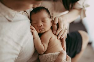 A series of tender newborn photography shots showing gentle hands holding and cradling a sleeping baby.