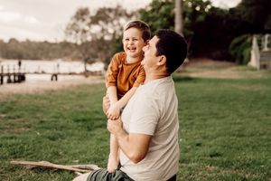 Family enjoying a warm sunset together in a grassy field during an outdoor photography session.