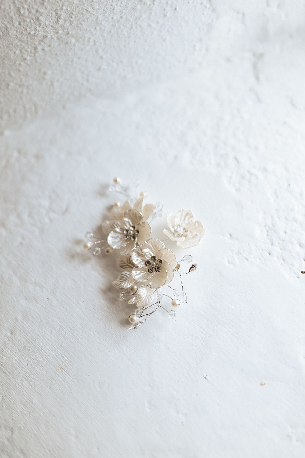 Small ethereal white flower arrangements arranged in a minimalist sequence against a textured white background.